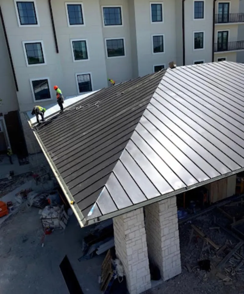 Crew installing standing seam metal roof panels on a commercial project in Milton-Freewater